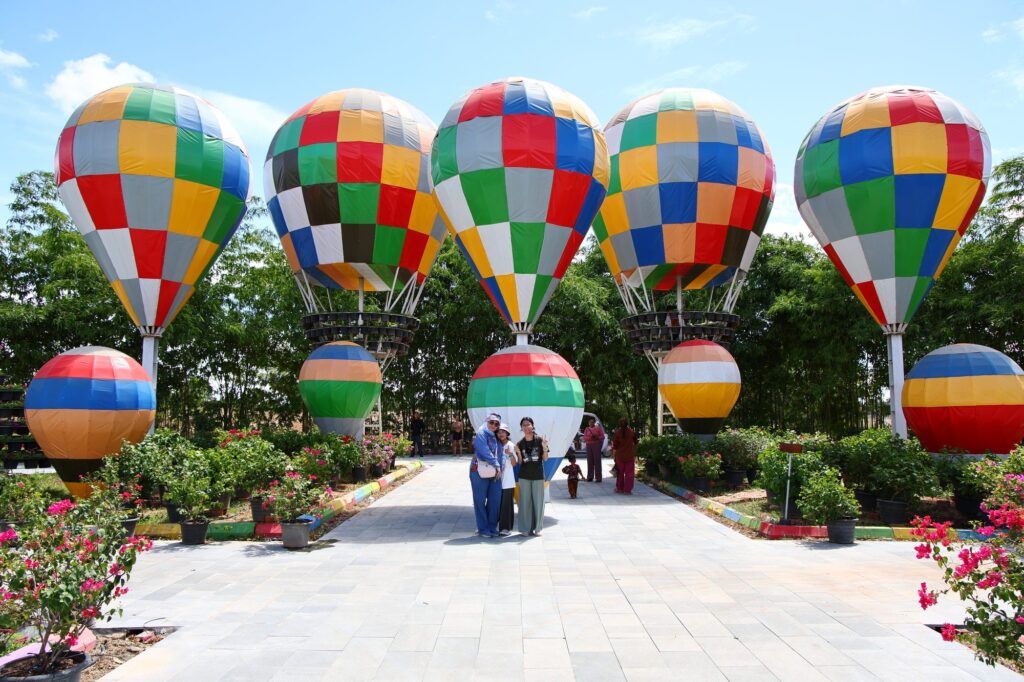 A path lined with colourful hot-air-balloon decorations at Angkor Wonder Garden