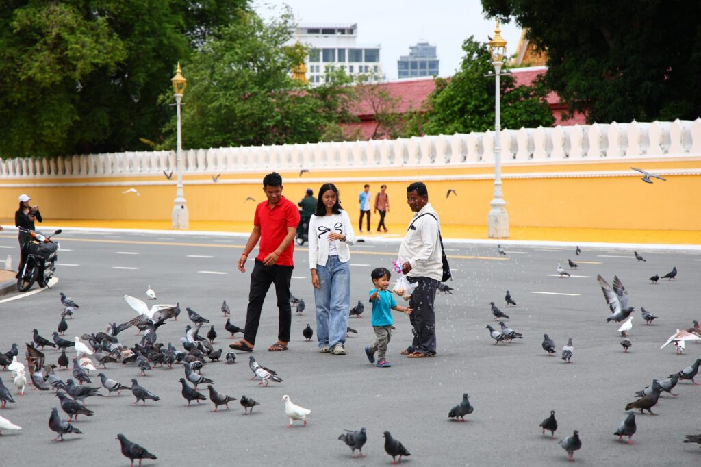 Kids chasing a flock of pigeons in the square outside the Royal Palace